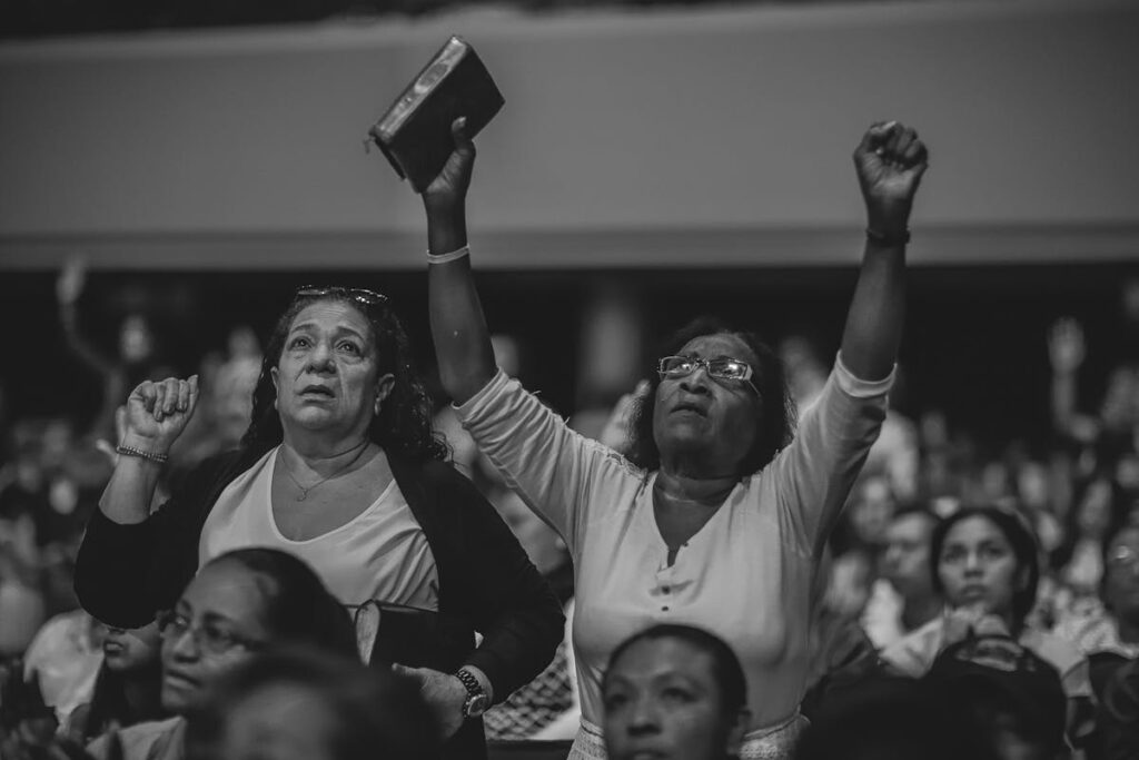 Two woman holding their arms up in a group setting