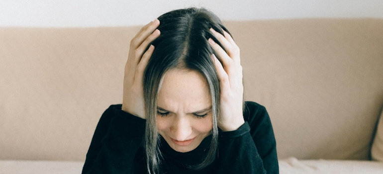Person holding their head.