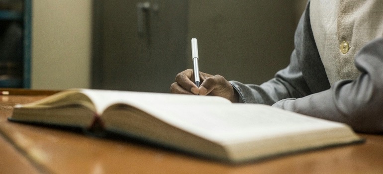 A person writing a diary, to understand the cycle of addiction