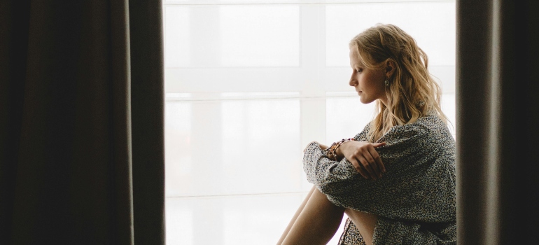 A person sitting quietly by a window.
