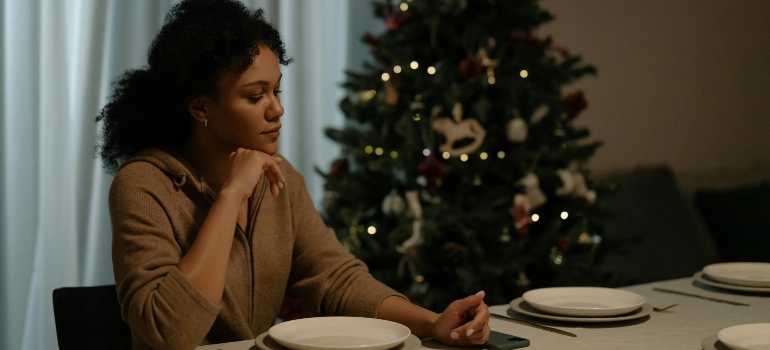 A person sitting at the table, thinking about starting an addiction treatment during the holidays.