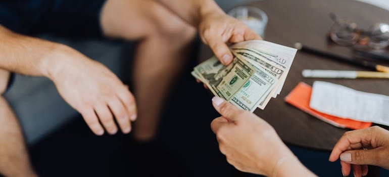 A person giving money to another person