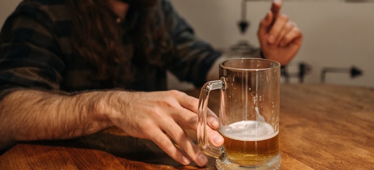 A person holding a glass of beer