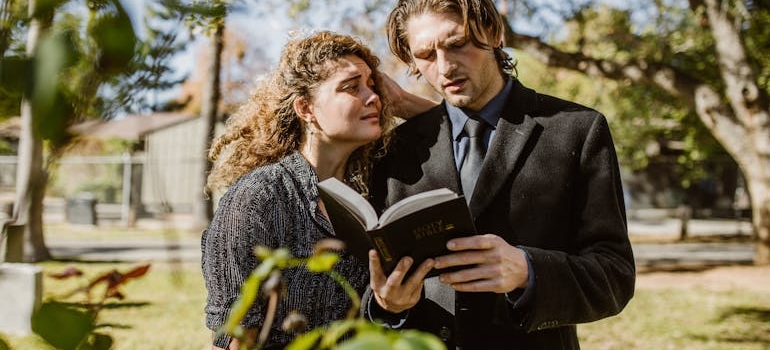 Two people reading about how to support someone in recovery through faith