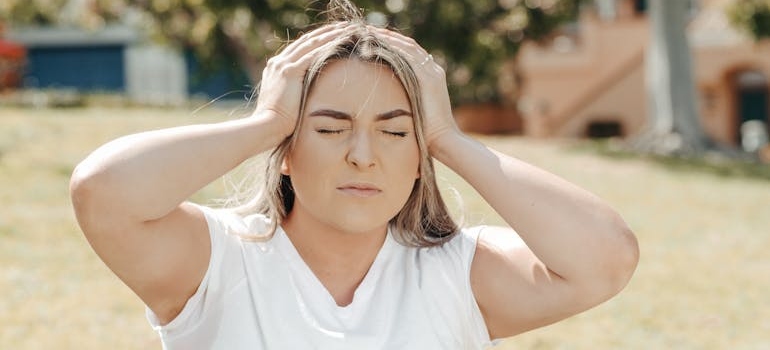 A womanholding her head