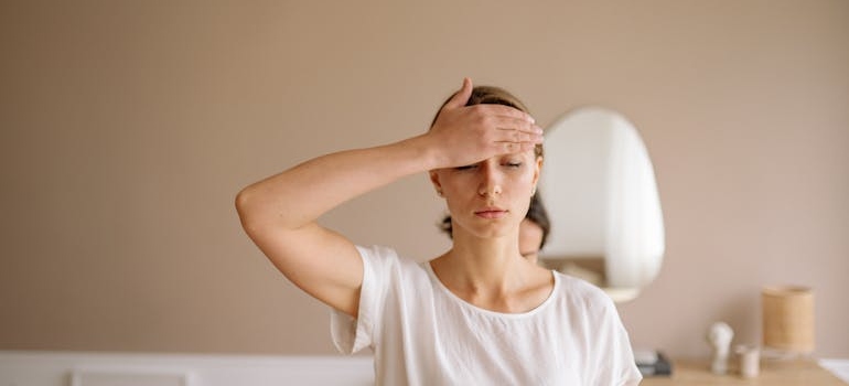 A woman holding her forehead