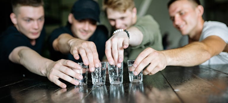 A group of men holding shots and talking about how substance abuse is impacting communities across Virginia