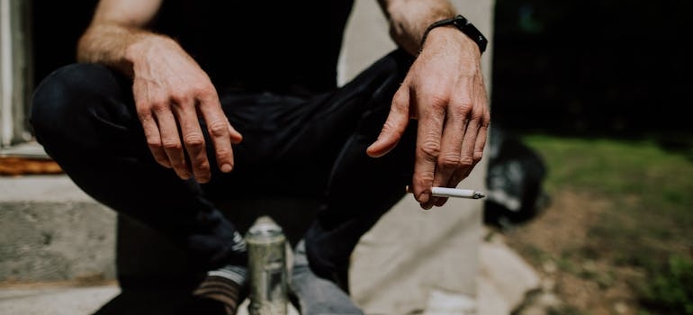 A person smoking and drinking